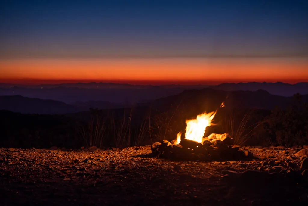 Small campfire burning at a backcountry campsite at dusk