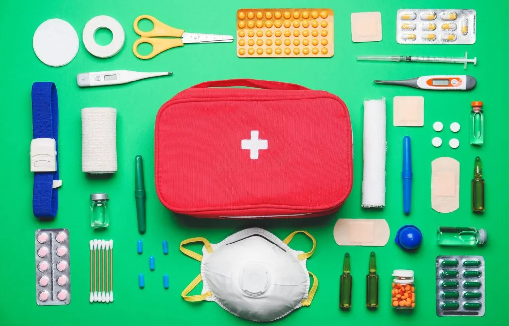 Open first aid kit with its contents laid out and organized