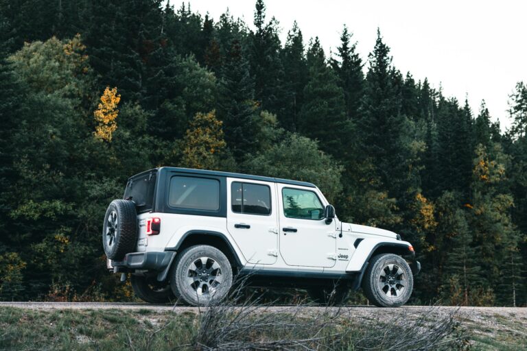White Jeep Wrangler parked on a forest road in Kananaskis, Alberta, Canada.