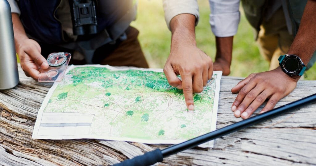 Topographic map in waterproof case on forest trail