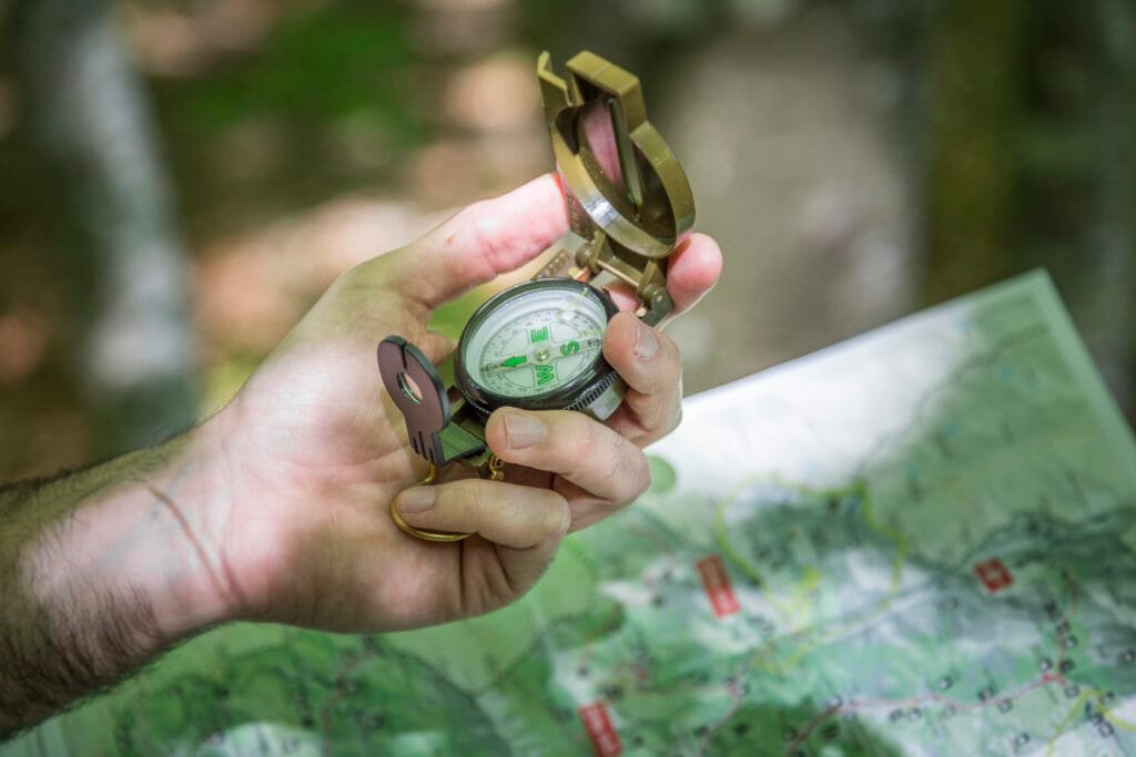 Compass and topographic map with hiking gear outdoors