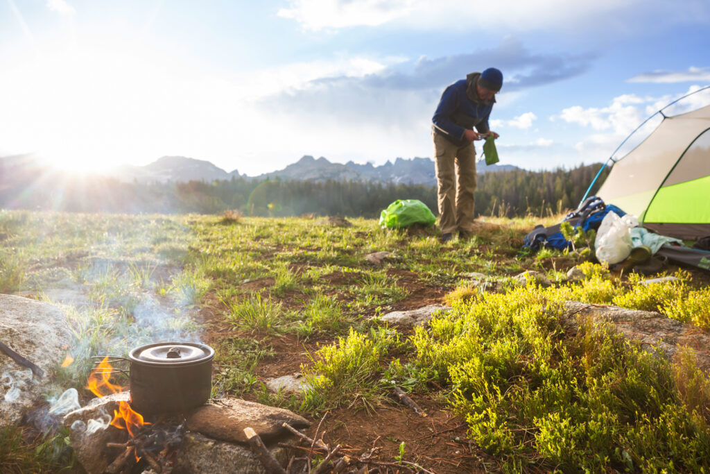 Hiking tent and campfire in camping in the mountains in summer season