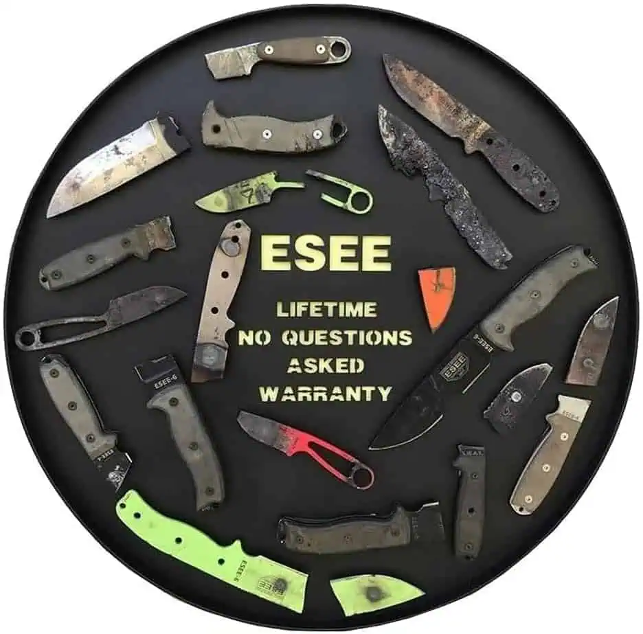 Used survival knives and tools displayed on a circular black tray with "ESEE Lifetimes No Questions Asked Warranty" text in the center.