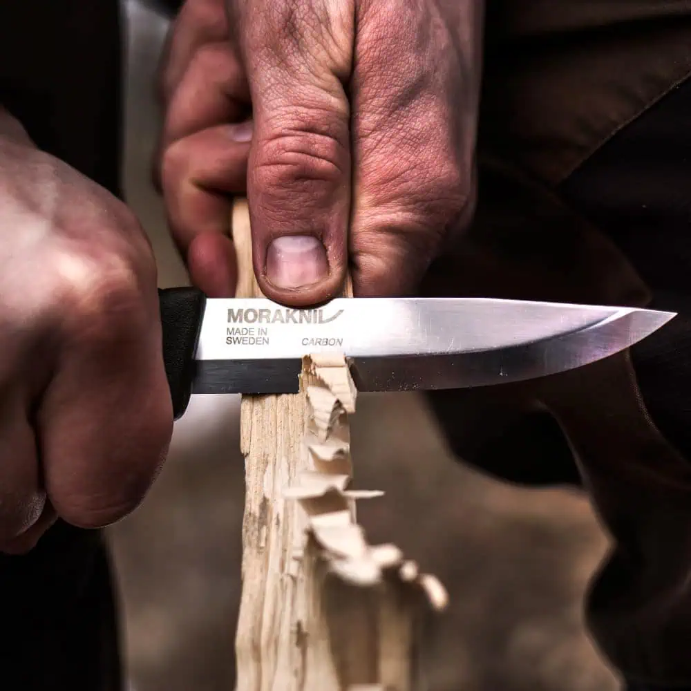 High-quality camping and outdoor survival knife cutting through wood, showcasing precision craftsmanship and durability for camping, hiking, and bushcraft enthusiasts.