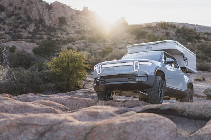 Electric truck with camper on rocks